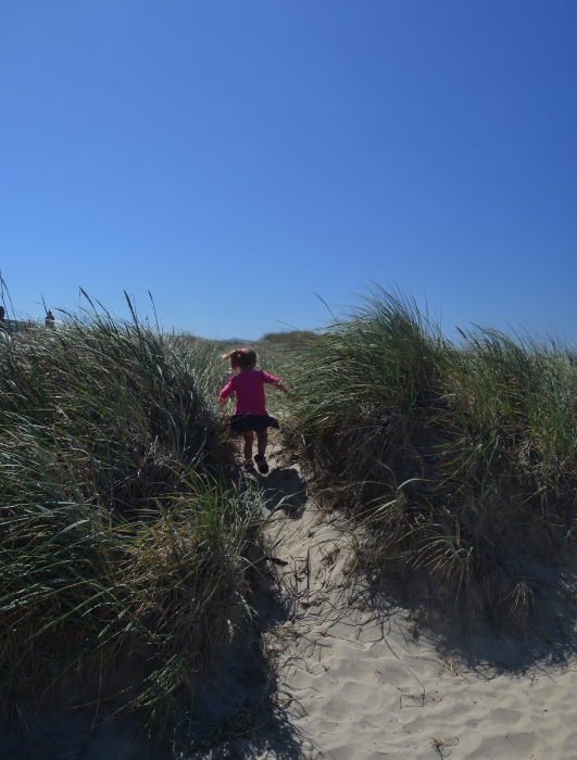 little girl running through the dunes